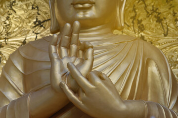 Golden hands of Buddha close up in mudra