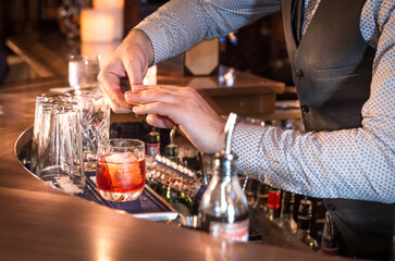 Bartender mixing, squeezing lemon/lime and preparing cocktails and alcoholic beverages in Vancouver cocktail bar and restaurants  