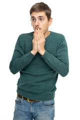 Young handsome tall slim white man with brown hair touching his mouth in dark green sweater in blue jeans isolated on white background