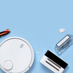 Modern white robot vacuum cleaner, filter, brush on blue background flat lay. New technologies, quick house cleaning, automatic robot assistant. Future technology, smart appliance for cleaning house