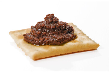 Toasted cracker with anchovies pate isolated on white background.