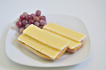Two Sandwiches with Camembert cheese and Grapes on  white Plate