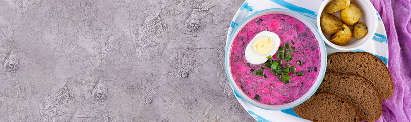 Cold borscht on wooden background. Cold beet soup. Top view. Banner