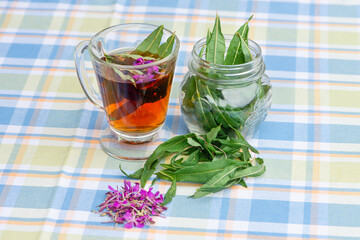 Cup of Fireweed herbal tea, fresh fireweed flowers and leaves.