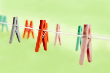 Colorful clothespins for drying clean laundry hang in nature on a clothesline in a row. copy space.