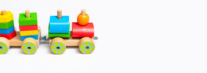 Wooden train with colored blocks on white background. Kids toys made of natural wood in rainbow colors. Eco friendly toy, game, plastic free. Toy for babies and toddlers. Flat lay side view
