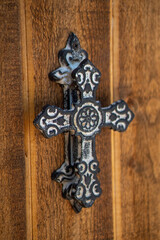 An ornate iron cross on a church door