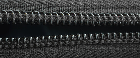 Open zipper on a black backpack, close-up textile, banner photo