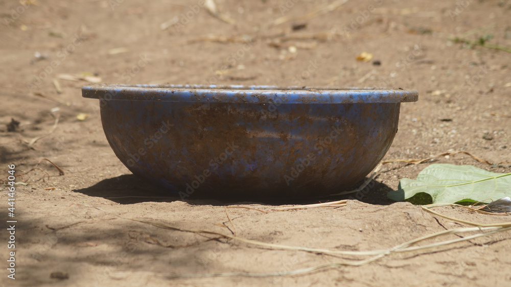 Wall mural Closeup shot of a rusty bowl on a sandy ground