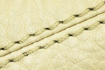 Fototapeta na wymiar Beige leather texture and the seam close-up background, high detailed surface photo