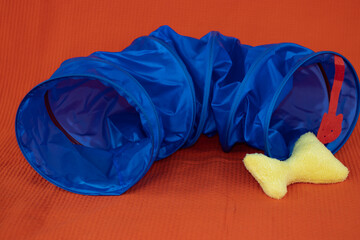 cat tunnel toy isolated from orange color background.