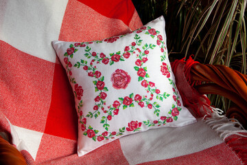 Decorative pillow with embroidery in the form of roses.