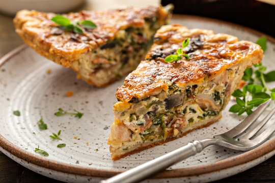 Bacon, mushroom and spinach quiche with cheese and herbs