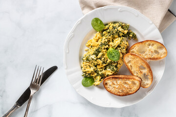 Huevos revueltos con espinacas y pan tostado