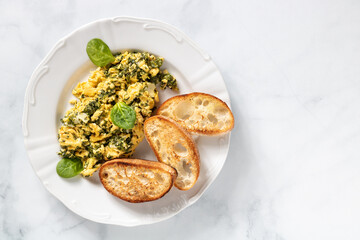 Huevos revueltos con espinacas y pan tostado