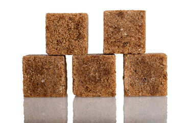 Dark refined sugar cubes stacked on top of each other, isolated on a white background