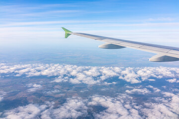 Obraz premium View from the airplane window at a beautiful blue sunrise and the airplane wing above the clouds.