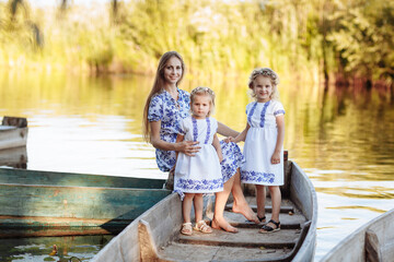 Fototapeta na wymiar young beautiful mother spending time together with children in boat on lake at park. mothers day. womens day