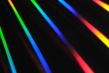 Holographic neon background. Neon rainbow strips on dark background. Soft focus Abstract rainbow color wave strips horizontal background.