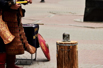 A large wooden anvil with a coin-chasing shape, a man in national clothing holds a hammer. Russia Kazan 24.04.2021. High quality photo