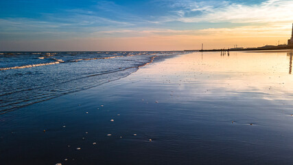 Fototapeta premium Sunset on a beach by industrial estate, Hove, Brighton, West Sussex, UK