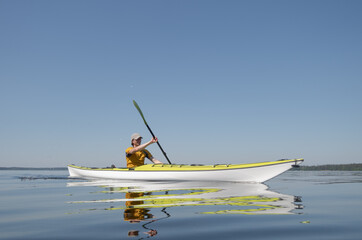 Obraz premium A man on a kayak glides on the surface of the water
