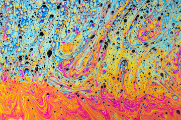 Fluid soap bubble psychedelic colorful abstract art. Surreal patterns with rainbows and waves of color in motion.