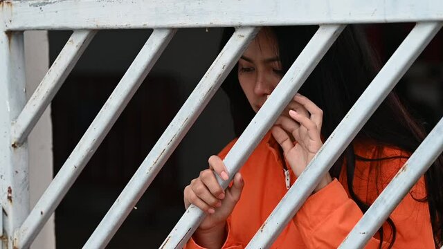 Portrait of women desperate to catch the iron prison,prisoner concept,thailand people,Hope to be free,If the violate the law would be arrested and jailed.