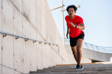 Athletic man running and doing exercise outdoors.