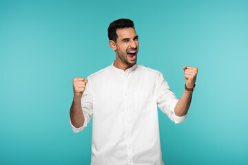Excited arabian man showing yes gesture isolated on blue