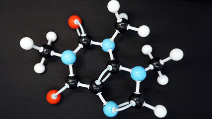 Model of a caffeine molecule (C8 H10 N4 O2) on a black background