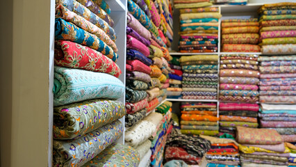 Traditional oriental multicolored fabricks stacked in store. Dubai market. Global village pavilion....