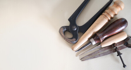 The tools for sewing leather goods. Handmade wallets, belts, bags on white cotton clothes background with free space for text or design.