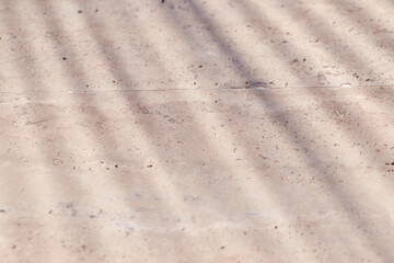 Exotic summer texture with tropical palm leaf top view shadows on beige natural stone wall. Minimal trendy abstract concrete background for cosmetic product presentation