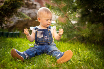 Sweet baby girl playing on green grass in park in spring time