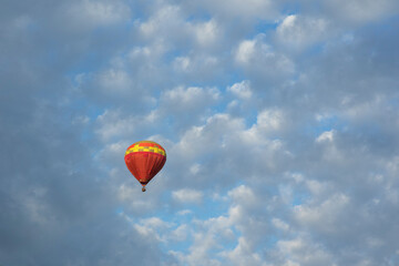 Colorful Hot Air Balloon in flight against a deep blue sky and clouds.