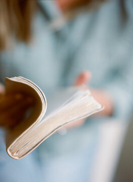 A woman opening a bible book to read