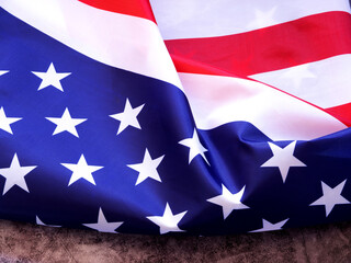 The beautiful fabric American flag on a grey background. Independence day concept. Copy space for your text. ..