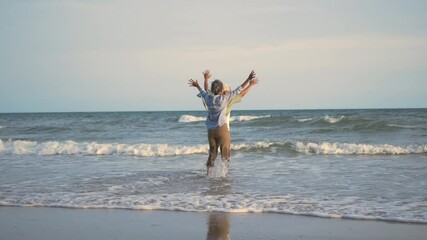 Happy Asian active senior man and woman couple lifestyle running to beach and enjoying funny, Romantic elderly enjoy travel summer vacation, plan life insurance at retirement couple concept