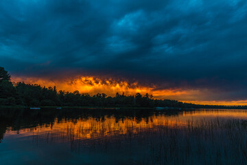 Obraz na płótnie Canvas Sunset above forest lake