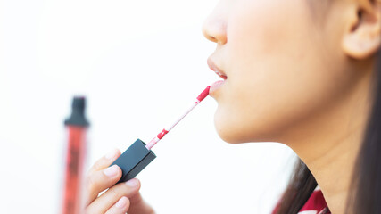 Fototapeta premium Young beautiful woman professional beauty applying lipstick cream to her mouth, doing a make up tutorial. Lifestyle Fashion Concept