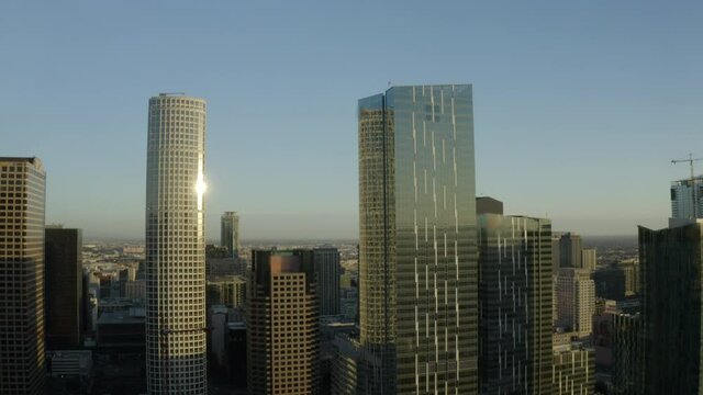 Aerial Rising Above The Soaring Skyscrapers And Downtown Skyline With Clear Blue Skies And Bright Sunlight Reflecting Off The Building Windows - Los Angeles, California