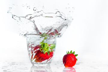 A strawberry splashes in a glass of water. fresh strawberries. Beautiful bursts of water. Healthy eating