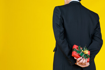 A man hiding gift behind for his lover. Times for anniversary 50 valentine together. This secret...