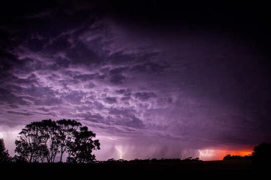 Lightning strikes in purple sky at sunset
