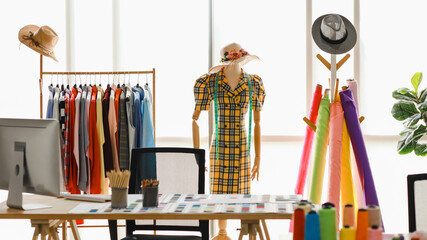 Body mannequin wearing hat and carrying measure are costume for fashion designer stylish  in dressing bright room with many colour garment and threads
