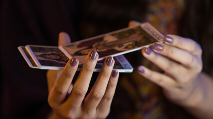 Crop woman reading future with tarot cards