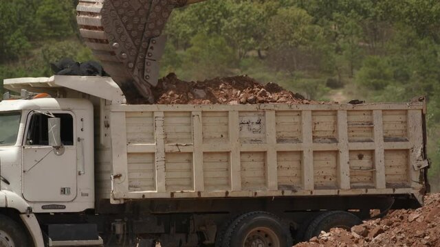 Cami&oacute;n de volteo cargando tierra y escombros en una construcci&oacute;n de casas