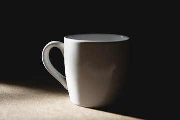Blank tea cup or coffee mug in black shadow background