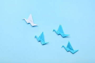 Origami birds on color background. Concept of uniqueness